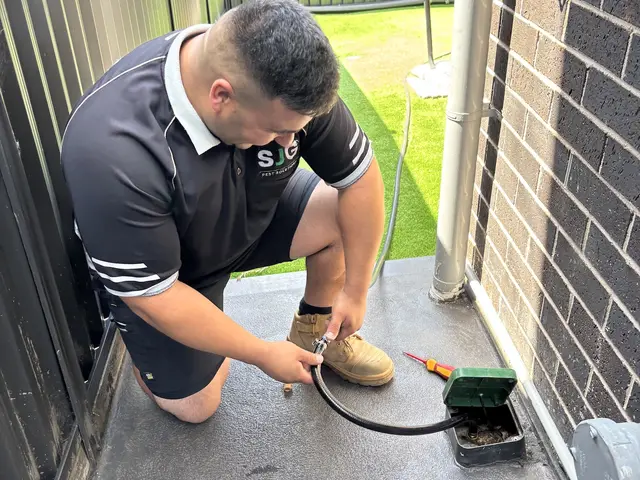 SJG technician servicing an in-ground termite station in a backyard